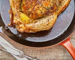 Image of seasoned whole chicken on a roasting pan