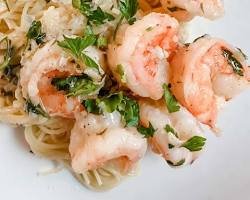 Image of garlic lemon shrimp scampi with parsley over white linguine pasta plate