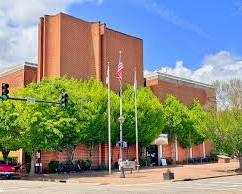 Image of person looking confused in front of a courthouse