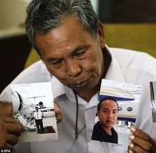 Painful wait: Malaysian Selamat Omar shows pictures of his son, Mohd Khairul Amri Selamat - article-2582504-1C556CAC00000578-316_634x627