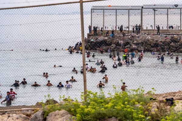 Runaway online rumors sparked migrants' frantic rush from Morocco into the Spanish enclave of Ceuta; Morocco says Spain should have foreseen court ruling's migration impact.