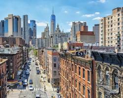 Image of person walking in New York City and looking up at the buildings