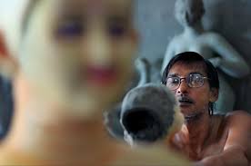 Narayan Pal is one of the potters at Kumartuli, Siliguri, West Bengal. Living statue of a sculptor. Painting the face. - 315