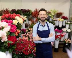 person smiling and holding a bouquet of colorful flowersの画像
