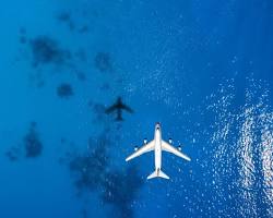 Image of plane flying over the ocean