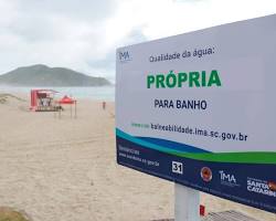 Imagem de Praia poluída com placas de proibição de banho