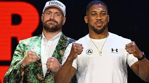 Tyson Fury and Anthony Joshua facing off during a press conference.