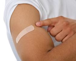 Image of person getting a bandaid on their arm