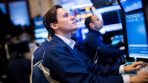 Traders monitor the Dow Jones Industrial Average at the New York Stock Exchange