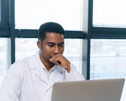 Imagen de person sitting at a desk, looking at a computer screen