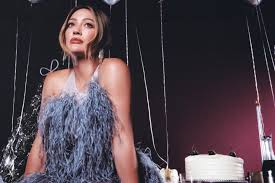 Hilary Duff smiling in a festive setting, promoting her new holiday EP.
