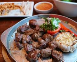 sizzling steak on a hot plate with side dishesの画像