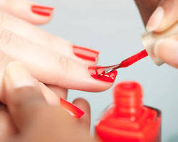 person having their nails painted red