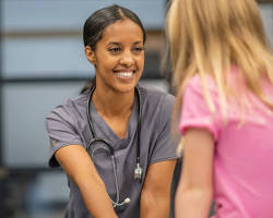 Image of school nurse with a stethoscope and a big smile