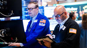 Traders work on the floor of the New York Stock Exchange as the Dow reaches a record high