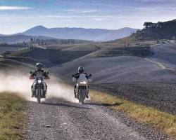 Immagine di motorcycle riding through a Tuscan countryside