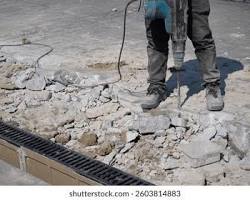 real construction worker breaking concrete floor jackhammer realistic photo، من إنشاء الذكاء الاصطناعي