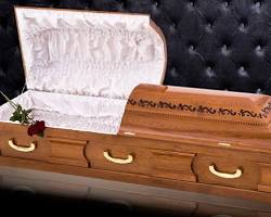 Image of Un angajat al unei firme de pompe funebre ajutând la transportarea unui sicriu