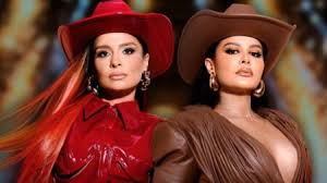 Duas mulheres com chapéus de cowboy, uma de vermelho e outra de marrom, posam para a câmera.