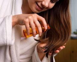 Image of woman applying castor oil to her hair