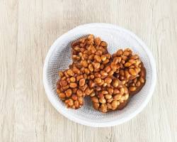 Gambar Ampyang, a crunchy snack made from peanuts and brown sugar, formed into a flat, round shape.