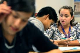 CSUF student Melissa Peralta is a tutor in the university&#39;s GEAR UP program and helps Sycamore Junior High School eighth-graders Dulce Tavera, foreground, ... - gear-up-melissa-peralta