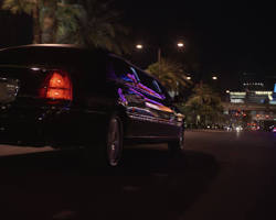 Image of Las Vegas Strip at night, with a limo driving down the road