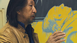 Wang Guangyi in his Beijing studio speaking with Andrew Cohen in front of recent works including “Death of Guides,” 2011. Stills from video shot by Julien ... - 77_features_wangguangyi_portrait3_web_576