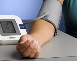 person checking their blood pressure with a digital monitorの画像