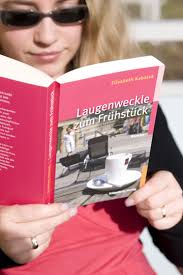 Elisabeth Kabatek Autorin. Foto: junge Frau liest Taschenbuch Laugenweckle ...