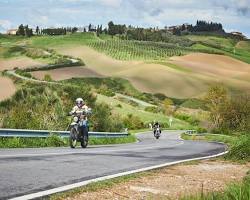 Immagine di motorcycle riding through a Tuscan countryside