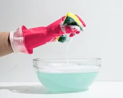 Image of a person carefully mixing a solution of water and dish soap in a bowl.