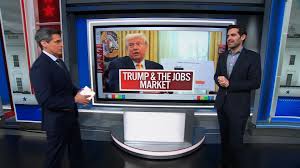 Two anchors discuss Trump and the jobs market in a news studio.