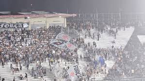 Torcedores do Vasco se protegem da chuva com bandeirões em São Januário