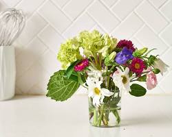 person spraying preserved flowers with hairspray