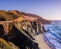 Image of someone relaxing on a California beach with a tax form in hand