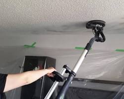 Primer and paint being applied to a freshly finished ceiling