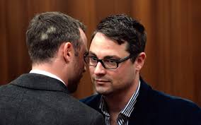 Oscar Pistorius speaks to his brother Carl Pistorius during the second day of his trial for the murder of his girlfriend Reeva Steenkamp at the North ... - 1152183926